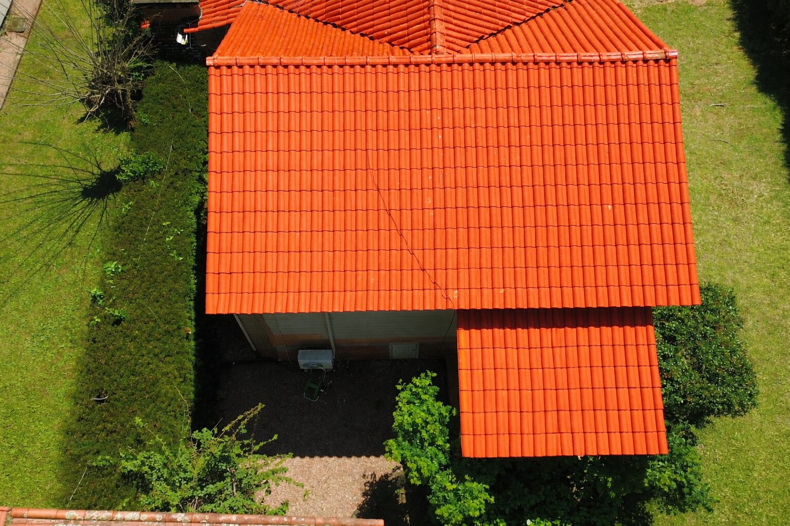 Telhado limpo apos lavagem profissional — vista aerea por drone